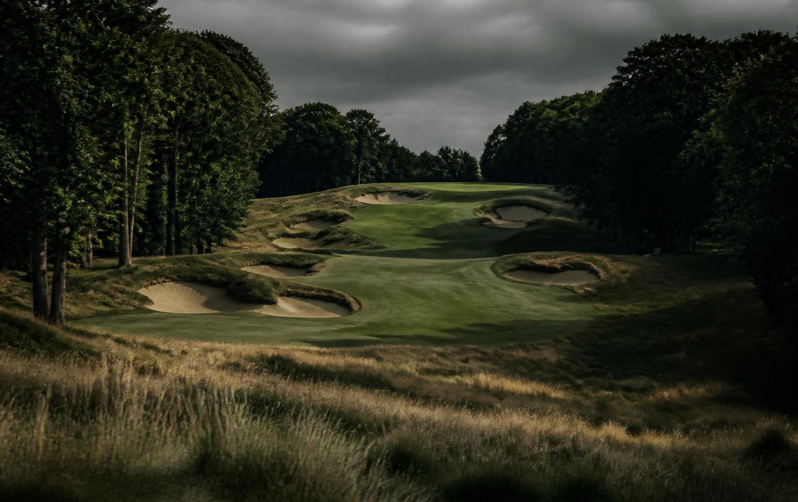 Deep sculpted bunkers guarding a parkland green